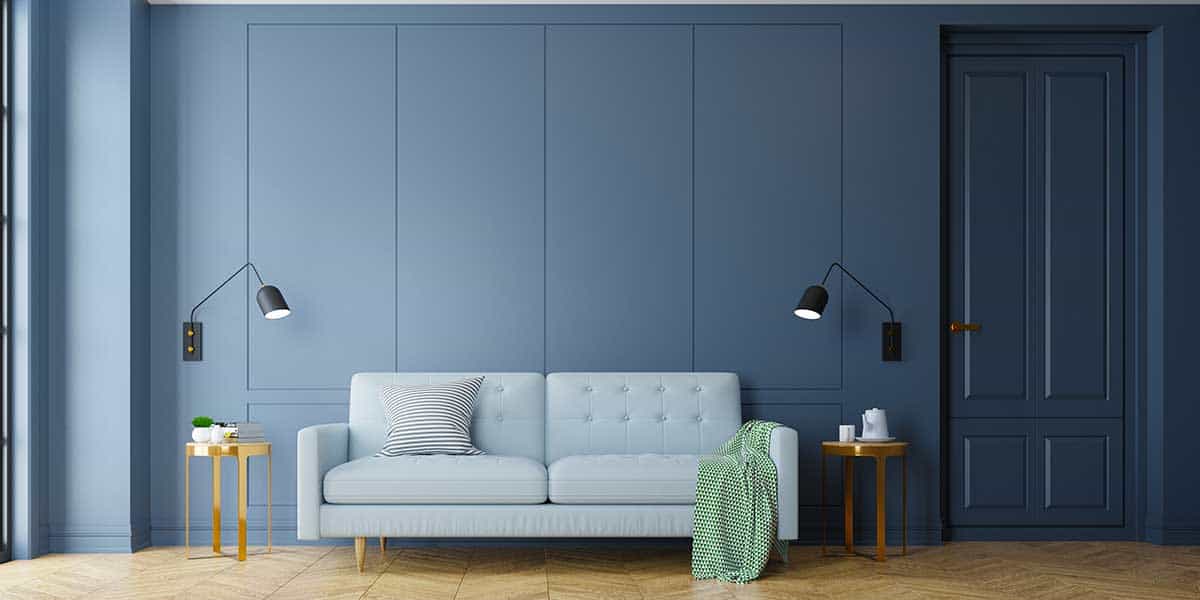 A modern living room featuring walls, trim, and door all painted in a cohesive, immersive shade of deep blue.
